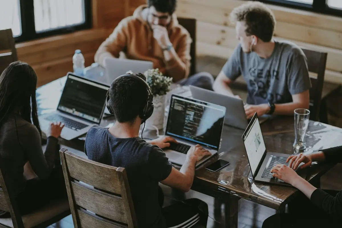 A product team planning a website together around their laptops
