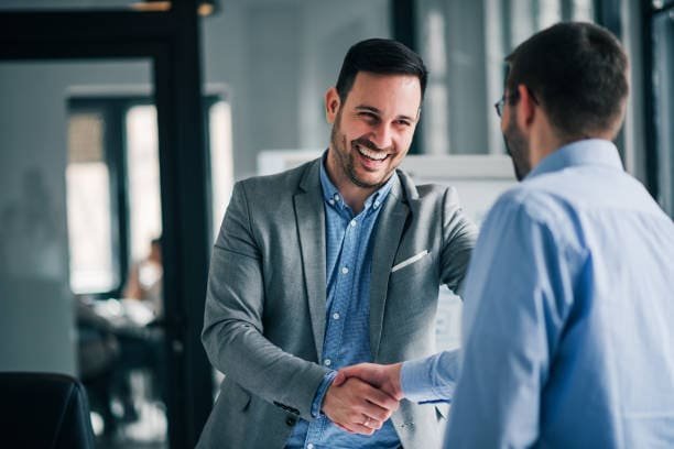 Client and project lead shaking hands after a successful project meeting